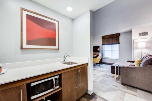 a kitchen with a sink and a living room at Hampton Inn & Suites Fort Worth Downtown in Fort Worth