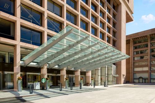 un gran edificio con un dosel de cristal delante de él en Hilton Washington DC National Mall The Wharf en Washington