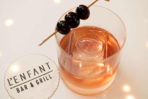 a glass of wine with a drink with black grapes on it at Hilton Washington DC National Mall The Wharf in Washington