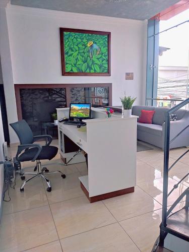 an office with a desk with a computer and a couch at Este Hotel in Estelí