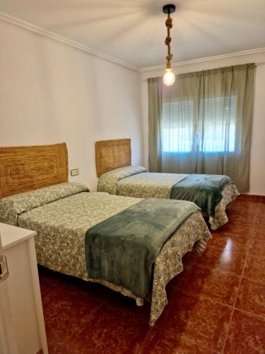 1 Schlafzimmer mit 2 Betten und einem Fenster in der Unterkunft Piso en Jarandilla de la Vera in Jarandilla de la Vera