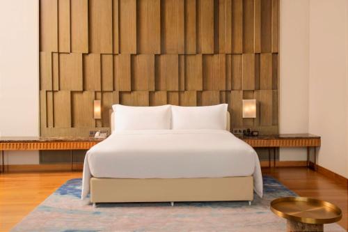 a bedroom with a white bed and two tables at DoubleTree by Hilton Weerawila Rajawarna Resort in Weerawila