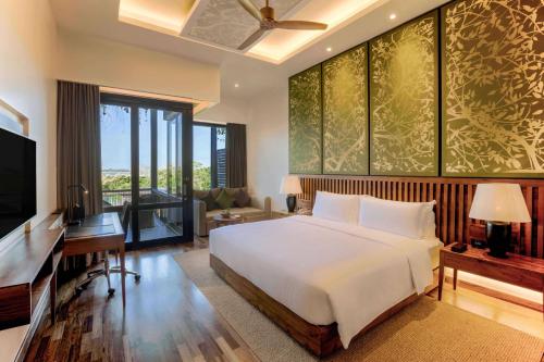 a bedroom with a bed and a desk and a television at DoubleTree by Hilton Weerawila Rajawarna Resort in Weerawila