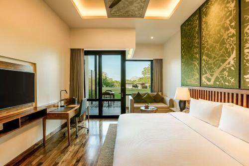 a hotel room with a bed and a television at DoubleTree by Hilton Weerawila Rajawarna Resort in Weerawila