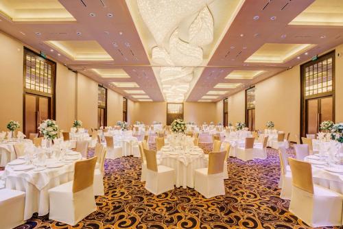 a banquet hall with white tables and chairs at DoubleTree by Hilton Weerawila Rajawarna Resort in Weerawila