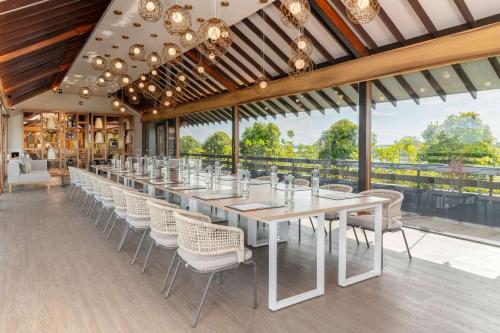 a long dining room with a long table and chairs at DoubleTree by Hilton Weerawila Rajawarna Resort in Weerawila