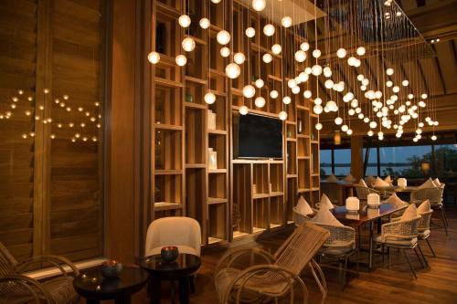 a dining room with a chandelier and tables and chairs at DoubleTree by Hilton Weerawila Rajawarna Resort in Weerawila