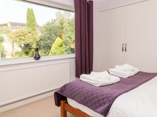 2 handdoeken op een bed in een kamer met een raam bij Milestones in Wells