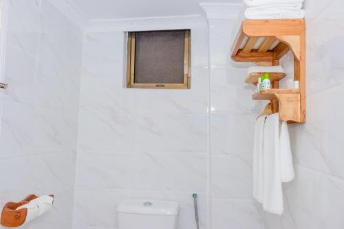 a bathroom with a toilet and a window at The Glacier Hotel Nanyuki in Nanyuki