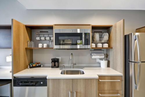 a kitchen with a sink and a microwave at Home2 Suites By Hilton Plano Richardson in Plano