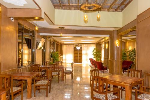 a restaurant with wooden tables and chairs at The Glacier Hotel Nanyuki in Nanyuki