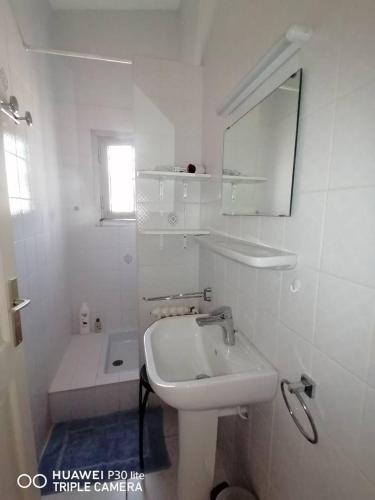 une salle de bain blanche avec un lavabo et un miroir dans l'établissement Chambre coquette dans villa proche de la plage, à Sète