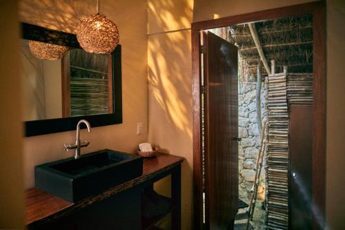 a bathroom with a sink and a glass shower at Our Habitas Tulum in Tulum