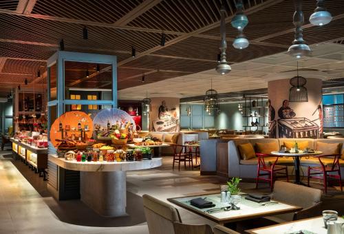 a restaurant with tables and chairs and a bar at DoubleTree by Hilton Surabaya in Surabaya