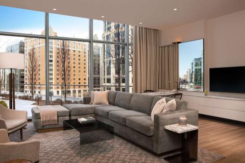 a living room with a couch and a large window at Conrad Washington DC in Washington, D.C.