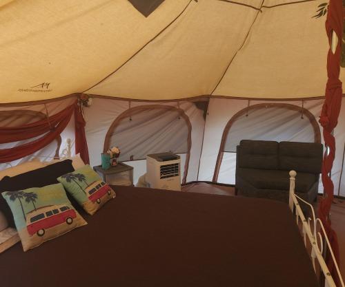a bedroom with a tent with a bed and a chair at Al's Hideaway Glamping Tents in Pipe Creek