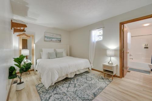 a white bedroom with a bed and a bathroom at 3 Mi to Silver Dollar City! Family Getaway w/ Pool in Branson