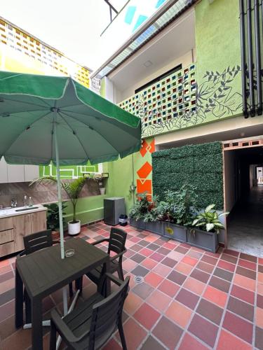 a patio with a table and chairs with an umbrella at CoLinkHouse Hotel in Medellín