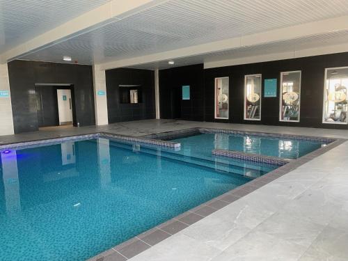 a large swimming pool with blue water in a building at Lyons Robin Hood Holiday Park, The Shamrock Way in Meliden