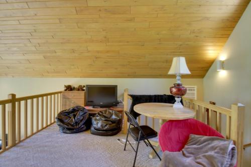 a living room with a table and a tv at Lakefront Brainerd Cabin with Fireplace! in Brainerd
