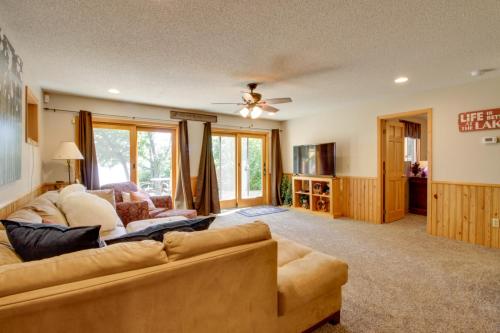a living room with a couch and a ceiling fan at Lakefront Brainerd Cabin with Fireplace! in Brainerd