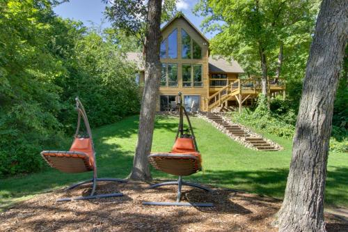 two chairs in front of a house with trees at Lakefront Brainerd Cabin with Fireplace! in Brainerd