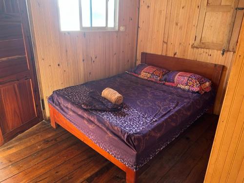 Cama pequeña en habitación de madera en Cabaña La Marea, en Bahía Solano