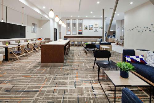 - un hall avec des tables, des chaises et un grand écran dans l'établissement Homewood Suites By Hilton San Diego Central, à San Diego