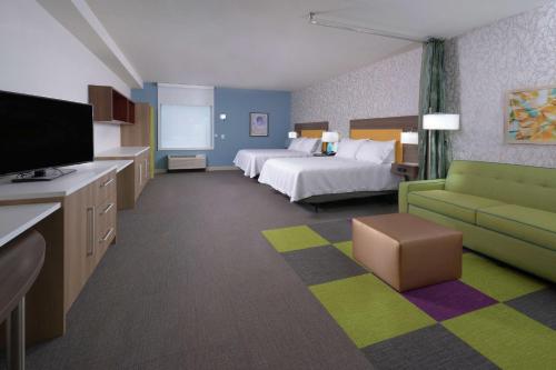 a large hotel room with a bed and a couch at Home2 Suites By Hilton Duncan in Duncan