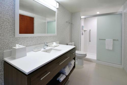 La salle de bains est pourvue d'un lavabo, de toilettes et d'un miroir. dans l'établissement Home2 Suites By Hilton Duncan, à Duncan