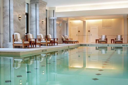 una gran piscina con sillas y mesas en Waldorf Astoria Atlanta Buckhead en Atlanta