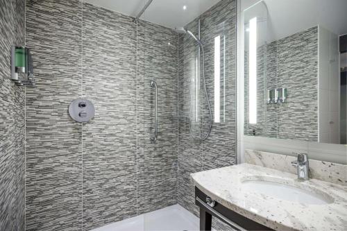 uma casa de banho com um chuveiro e um lavatório. em Hampton By Hilton Stockton On Tees em Stockton-on-Tees