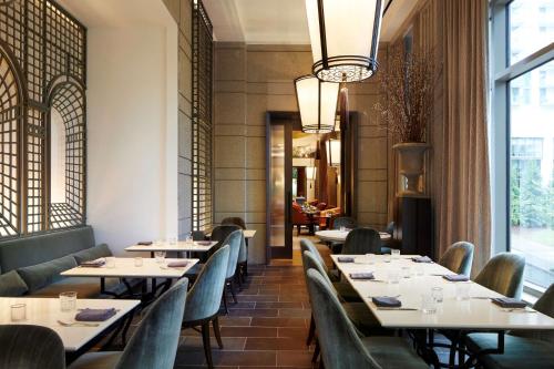 a restaurant with tables and chairs and a chandelier at Waldorf Astoria Atlanta Buckhead in Atlanta