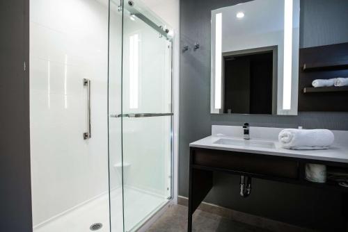 a bathroom with a glass shower and a sink at Hilton Garden Inn West Palm Beach I95 Outlets in West Palm Beach
