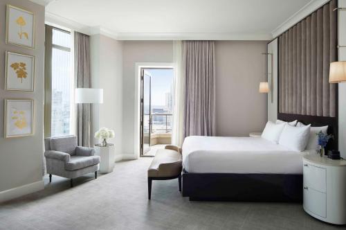 a hotel room with a bed and a chair at Waldorf Astoria Atlanta Buckhead in Atlanta