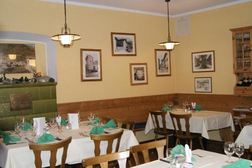 une salle à manger avec des tables et des chaises blanches dans l'établissement Albergo Piz Cam, à Vicosoprano