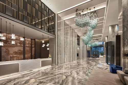 a lobby of a building with a chandelier at Doubletree By Hilton Suzhou Wujiang in Suzhou