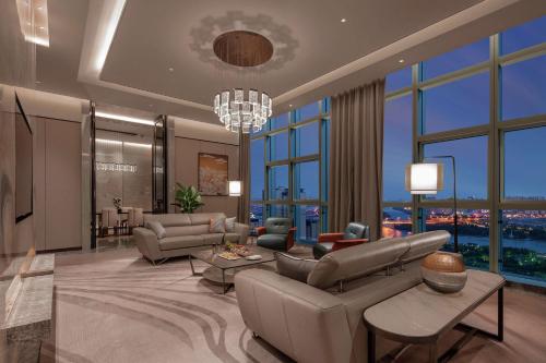 a living room with couches and a chandelier at Doubletree By Hilton Suzhou Wujiang in Suzhou