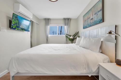 a white bedroom with a large bed and a window at Tower 9 #6 in Oceanside