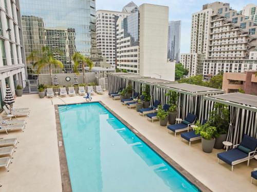 an overhead view of a swimming pool on a building with chairs at Carte Hotel San Diego Downtown, Curio Collection By Hilton in San Diego