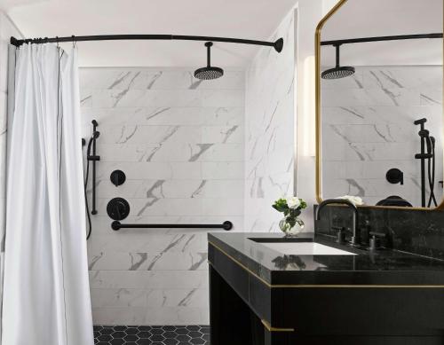 a bathroom with a black sink and a mirror at C. Baldwin, Curio Collection by Hilton in Houston