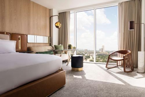 ein Hotelzimmer mit einem Bett und einem großen Fenster in der Unterkunft C. Baldwin, Curio Collection by Hilton in Houston