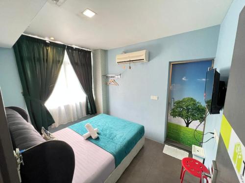 a bedroom with a bed with a teddy bear on it at The Tree Boutique Hotel in Shah Alam