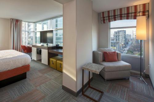 um quarto de hotel com uma cama, uma cadeira e uma secretária em Hampton Inn & Suites Atlanta-Midtown, Ga em Atlanta