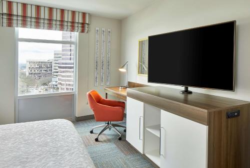 a hotel room with a television and a desk with a chair at Hampton Inn & Suites Atlanta-Midtown, Ga in Atlanta