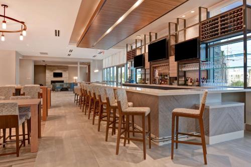 a bar in a restaurant with chairs and tables at Hilton Garden Inn Destin Miramar Beach, Fl in Destin