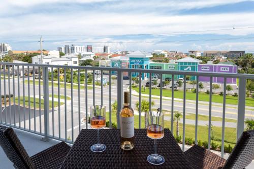 a table with two glasses of wine on a balcony at Hilton Garden Inn Destin Miramar Beach, Fl in Destin