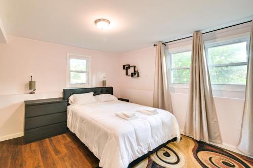 a bedroom with a bed with white sheets and a window at Waltham Vacation Rental about 12 Mi to Downtown Boston in Waltham