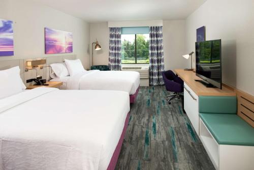 a hotel room with two beds and a flat screen tv at Hilton Garden Inn Seattle Lynnwood, Wa in Lynnwood