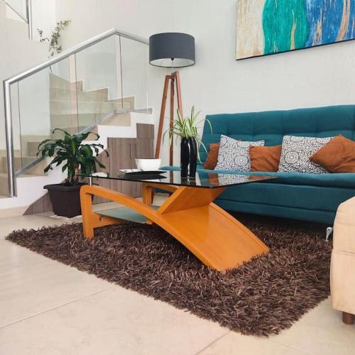 sala de estar con sofá azul y mesa en Comodidad y Tranquilidad a tu Alcance en San Juan del Río
